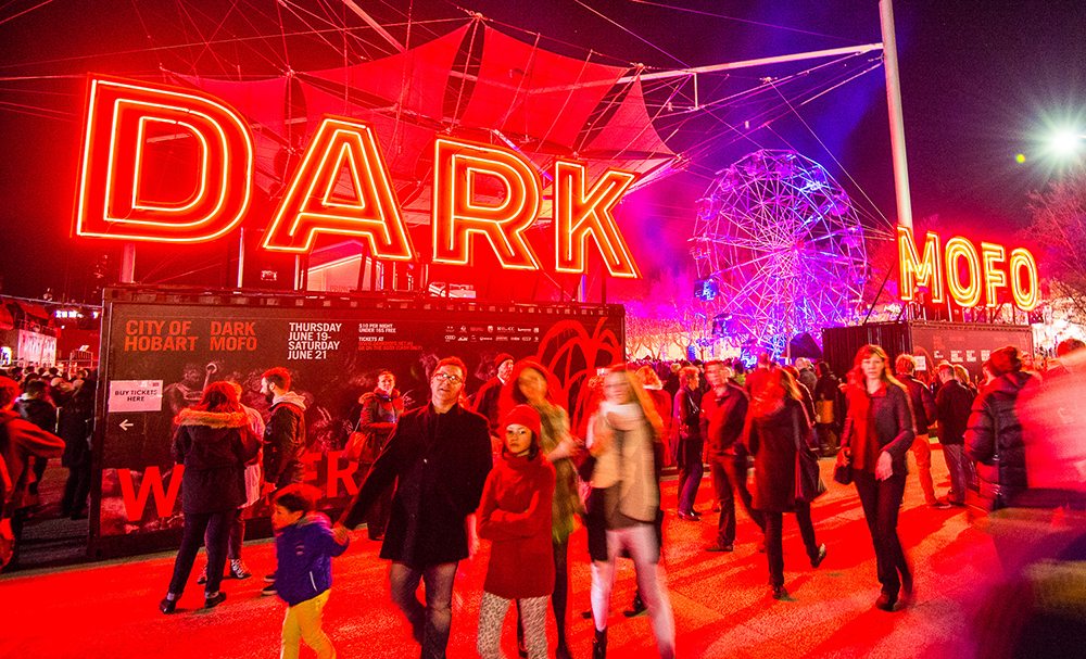 Attendees walk around the Dark Mofo Festival at night. Red lights everywhere