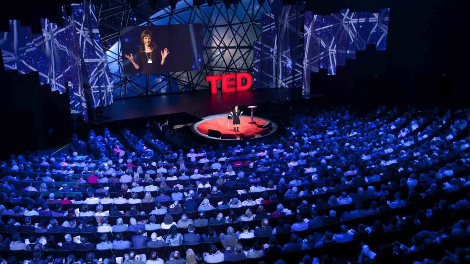 A TED X crowd listening to a TED X speak on stage